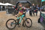 Woman with a downhill bicycle poses at the finish line of the Downhill Southeast race